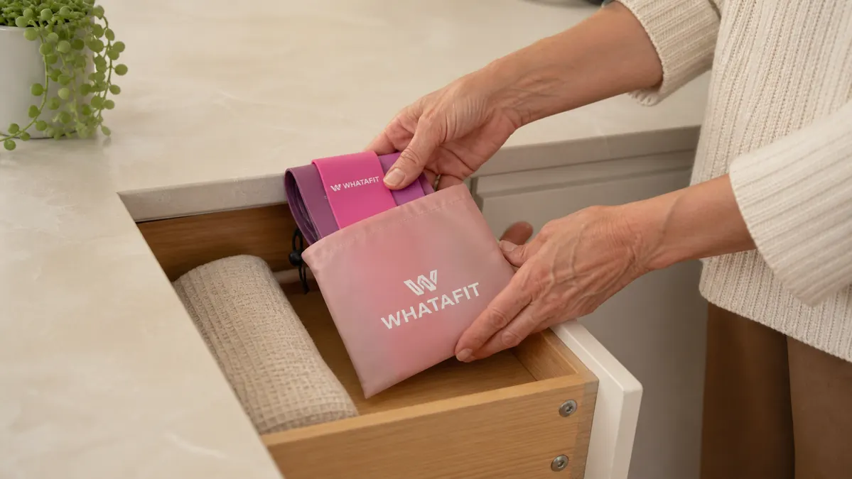 A person folding the band set into a small storage pouch and sliding it into a drawer